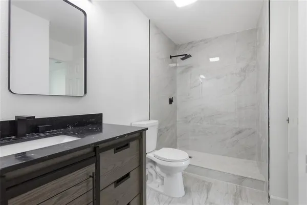 a bathroom with a sink a toilet and shower