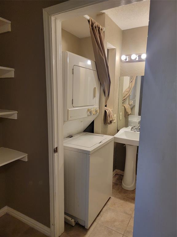 9803 Walnut Street, Unit 102 Dallas, TX 75243 - Photo 14 of 17 Compact laundry area featuring a stacked washer and dryer unit
