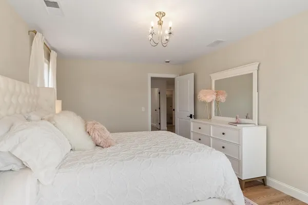 a bedroom with a large bed and a chandelier
