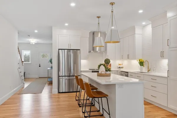 a kitchen with stainless steel appliances granite countertop a refrigerator a sink and a stove