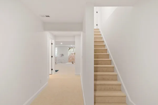 a view of a hallway with wooden floor and entryway