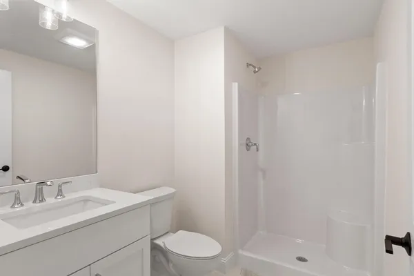 a bathroom with a granite countertop sink toilet a mirror and shower