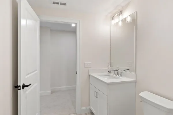 a bathroom with a sink a toilet and a mirror