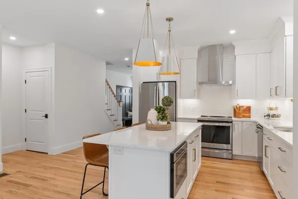 a kitchen with stainless steel appliances kitchen island granite countertop a stove a sink and a refrigerator
