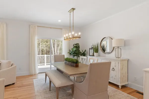 a dining room with furniture a chandelier and wooden floor