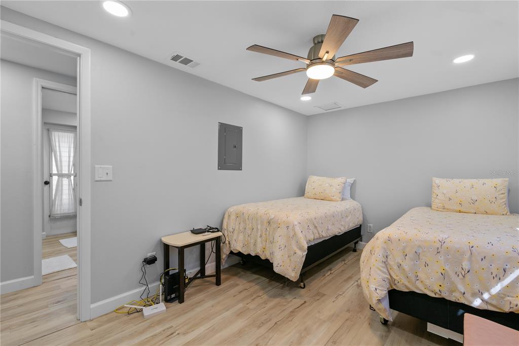 2476 North Beach Road Englewood, FL 34223 - Photo 28 of 58 a bedroom with two beds and a chandelier