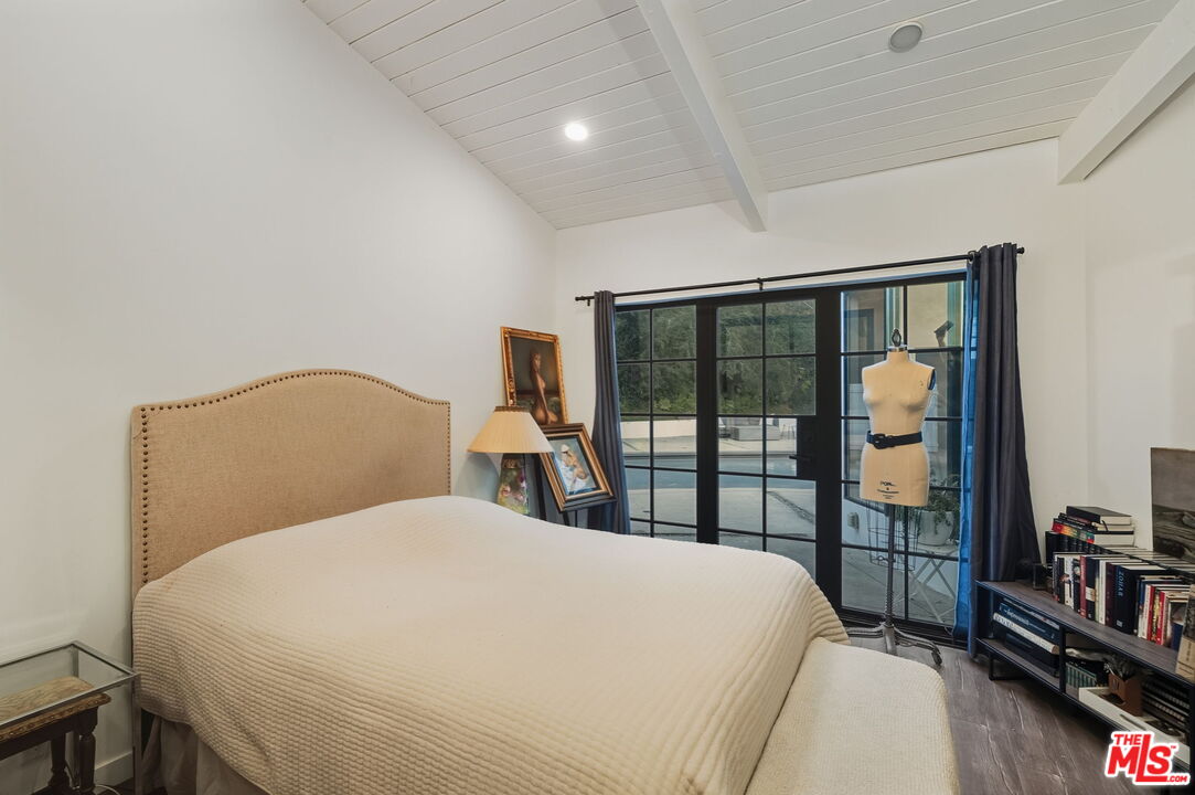 13019 Sky Valley Road Los Angeles, CA 90049 - Photo 23 of 39 a bedroom with a large bed and a tv