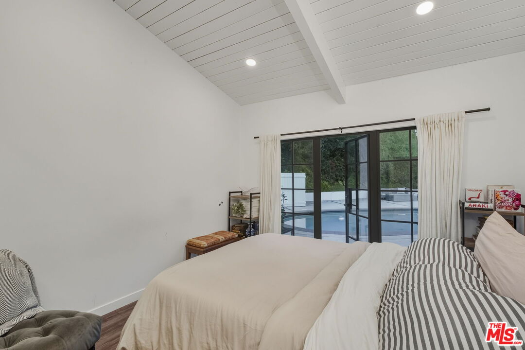 13019 Sky Valley Road Los Angeles, CA 90049 - Photo 24 of 39 a bedroom with a bed and a large window