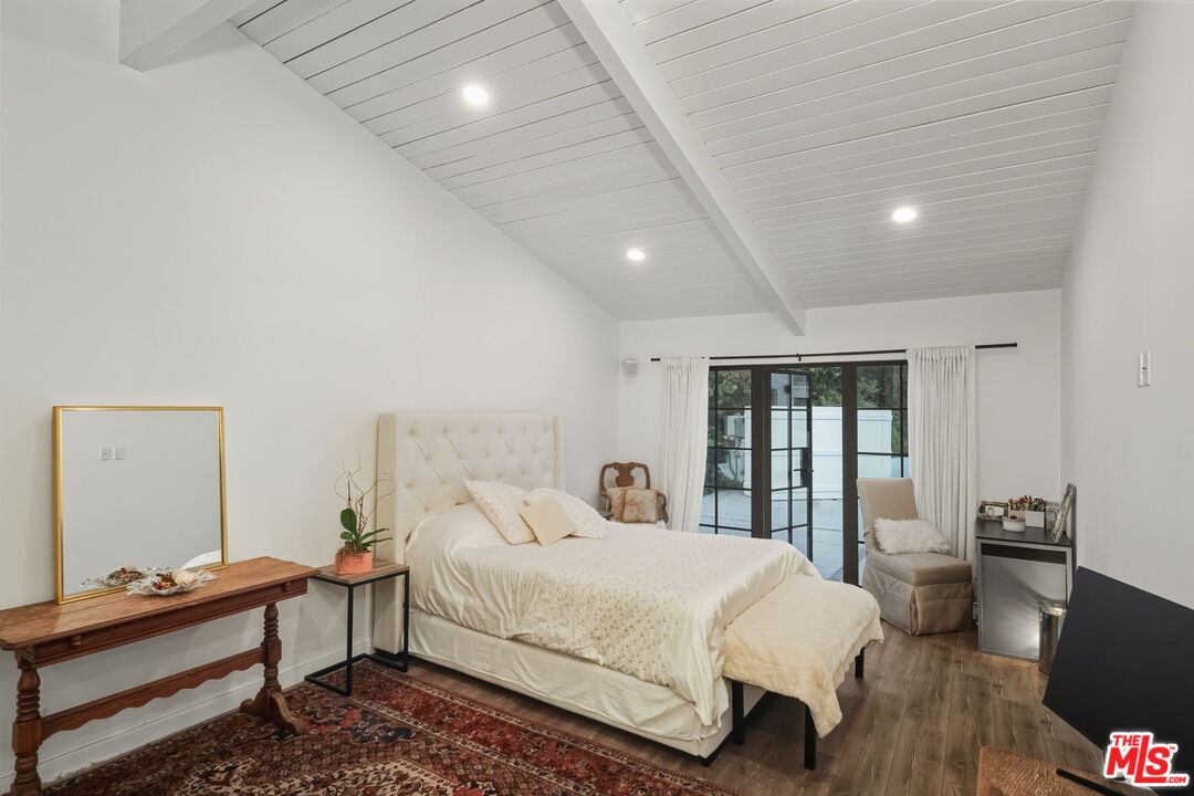 13019 Sky Valley Road Los Angeles, CA 90049 - Photo 25 of 39 a bedroom with a bed and wooden floor