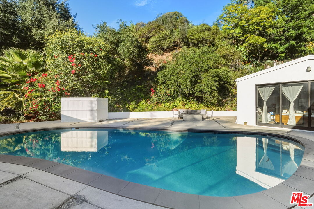 13019 Sky Valley Road Los Angeles, CA 90049 - Photo 33 of 39 a view of a swimming pool with a patio and a yard
