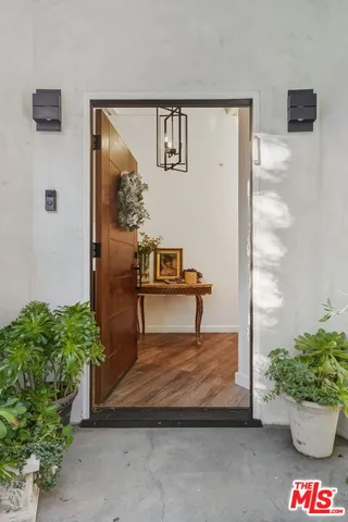 a living room with furniture large window and wooden floor