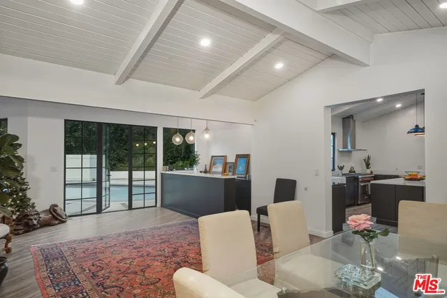a living room with furniture large window and wooden floor