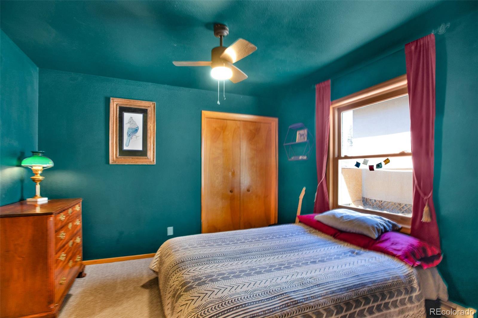 757 Thompson Park Road Fairplay, CO 80440 - Photo 15 of 49 a bedroom with a bed and a chandelier