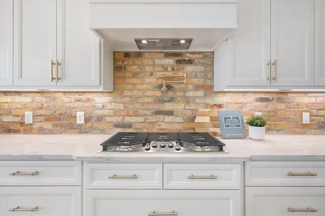 a kitchen with granite countertop white cabinets and white appliances