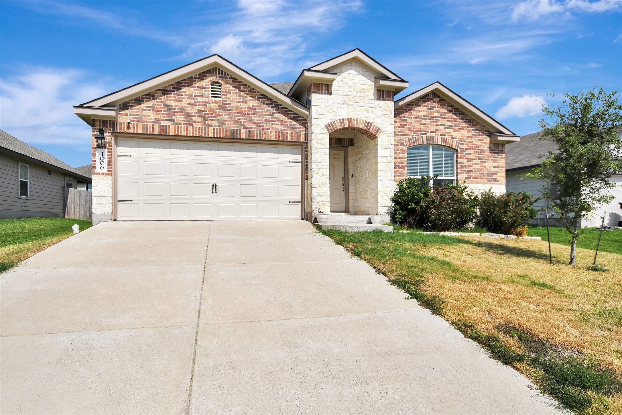 Charming curb appeal with a welcoming front porch, fresh landscaping, and plenty of parking space.