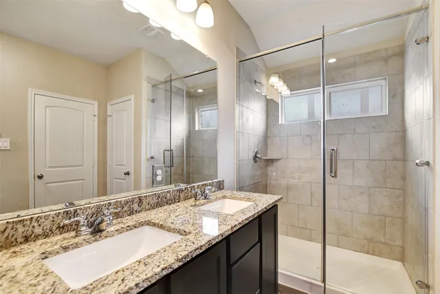 a bathroom with a granite countertop sink shower and a mirror