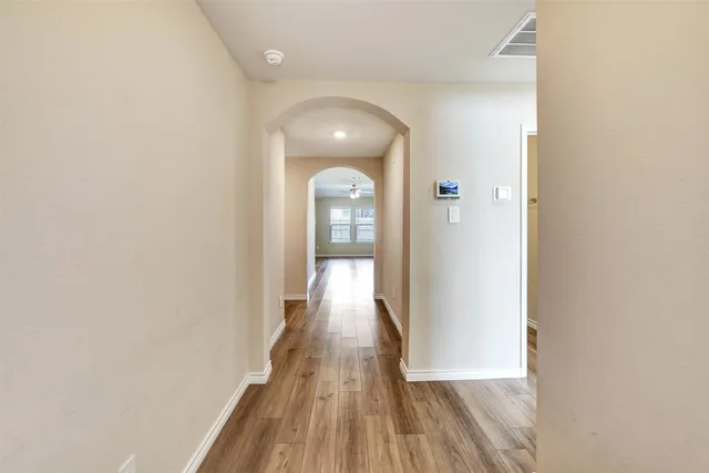 a view of a hallway with wooden floor and staircase