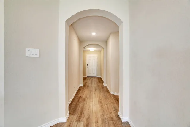 a view of a hallway with wooden floor