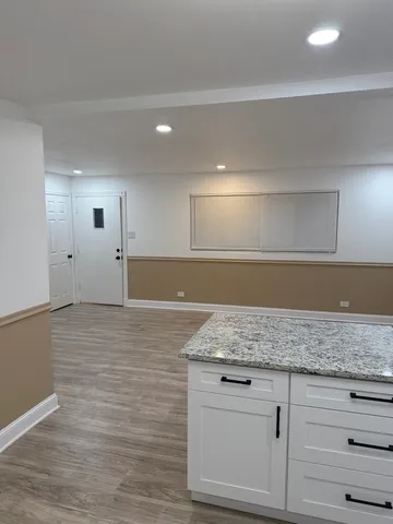a kitchen with granite countertop a sink and a white cabinets
