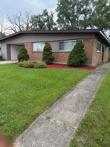 a front view of house with a garden