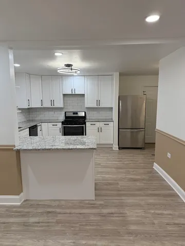 a kitchen with stainless steel appliances granite countertop a refrigerator sink and cabinets