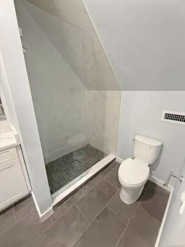a bathroom with a toilet and a shower