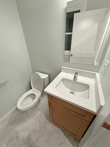 a bathroom with a sink toilet and mirror