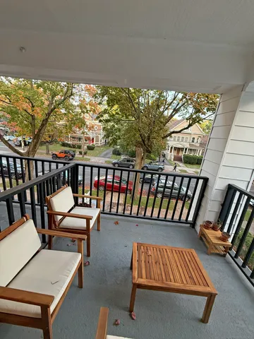 a balcony with wooden floor outdoor seating and city view