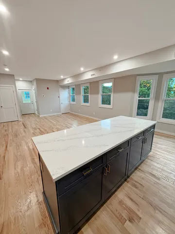 a view of kitchen island wooden floor and living room