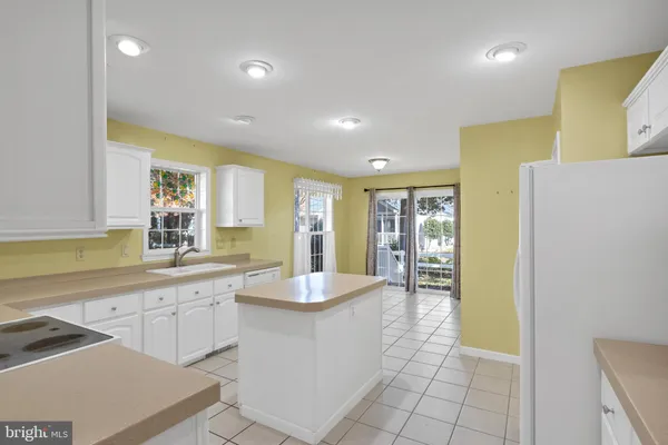 a large kitchen with kitchen island a sink a counter top and stainless steel appliances