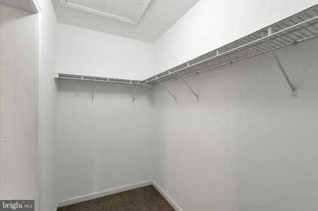 a view of an empty room with a chandelier fan