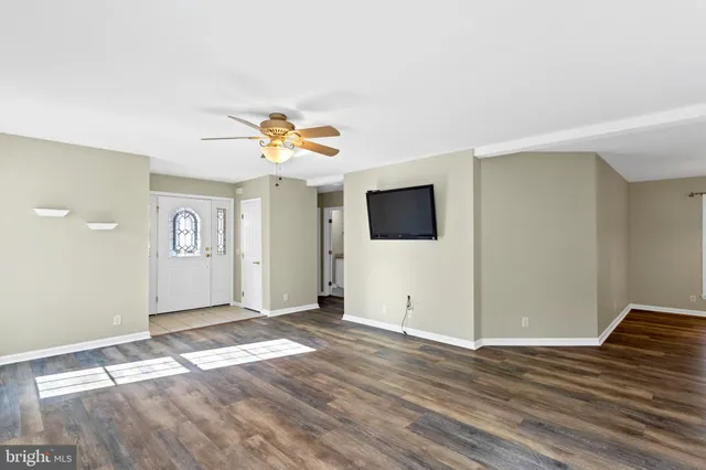 a view of a livingroom with wooden floor and a flat screen tv