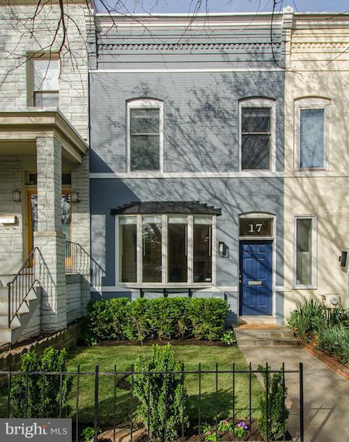 front view of a brick house with a small yard