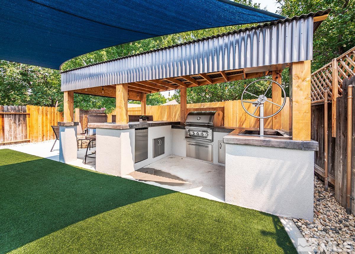7686 Barnsdale Road Reno, NV 89511 - Photo 20 of 27 a view of a patio with couches chairs under an umbrella