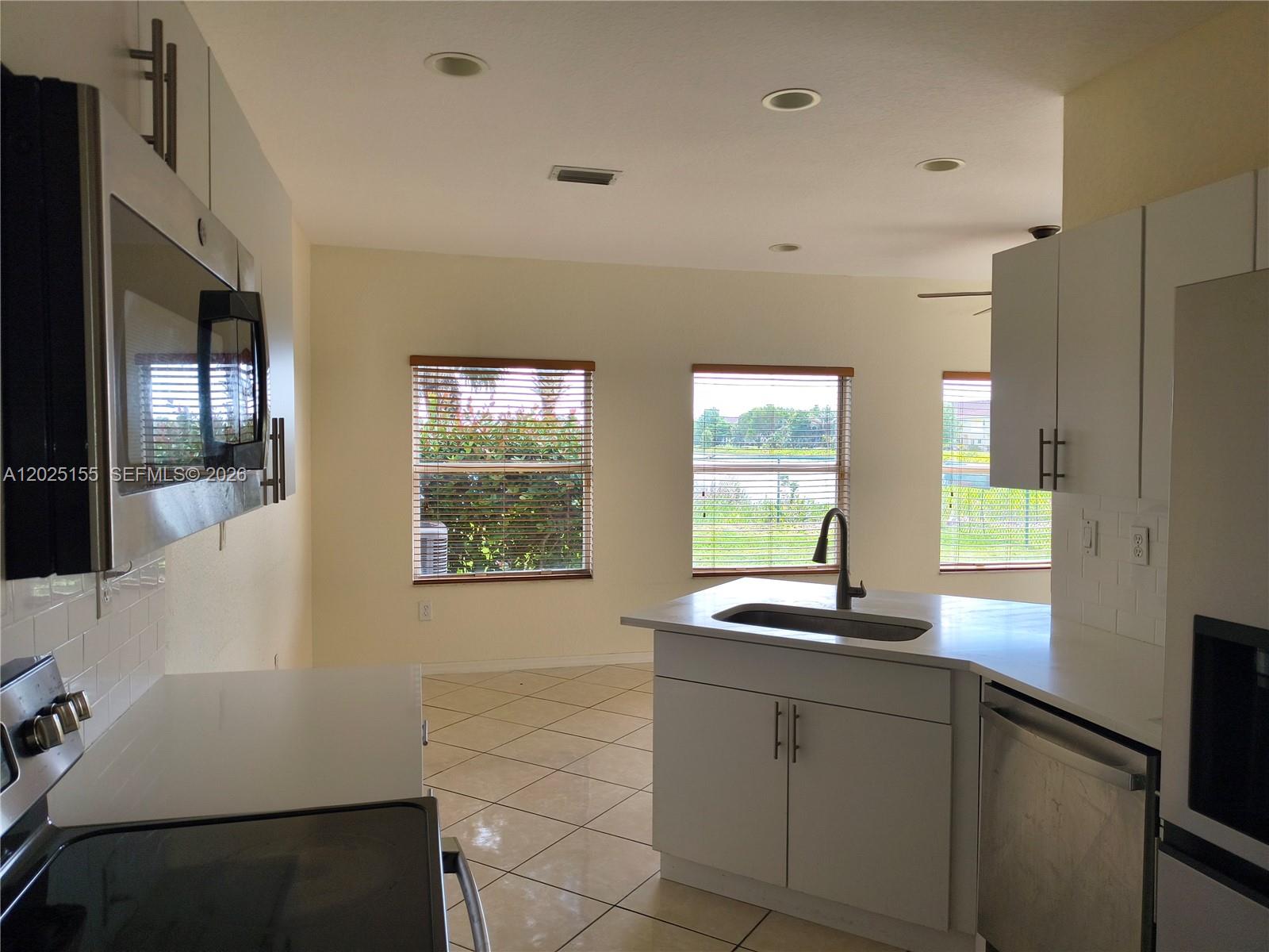 1645 Southeast 20th Road, Unit 1645 Homestead, FL 33035 - Photo 2 of 20 a kitchen with a sink and large window