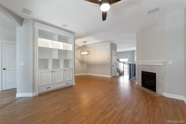 a view of an empty room with wooden floor fireplace and a window