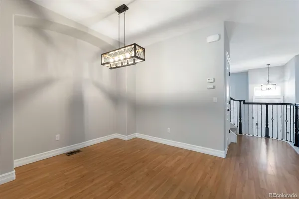 a view of a room with wooden floor and ceiling fan