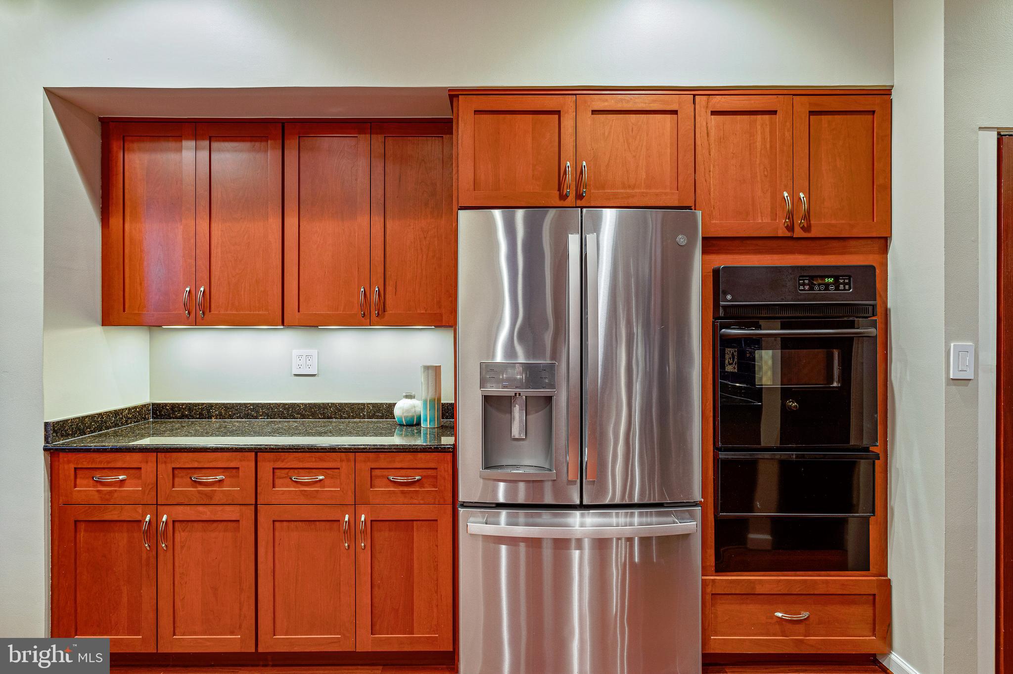 144 Tennessee Avenue Northeast Washington, DC 20002 - Photo 24 of 68 a kitchen with granite countertop wooden cabinets and a refrigerator
