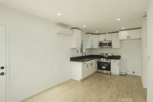 a kitchen with granite countertop white cabinets and white appliances