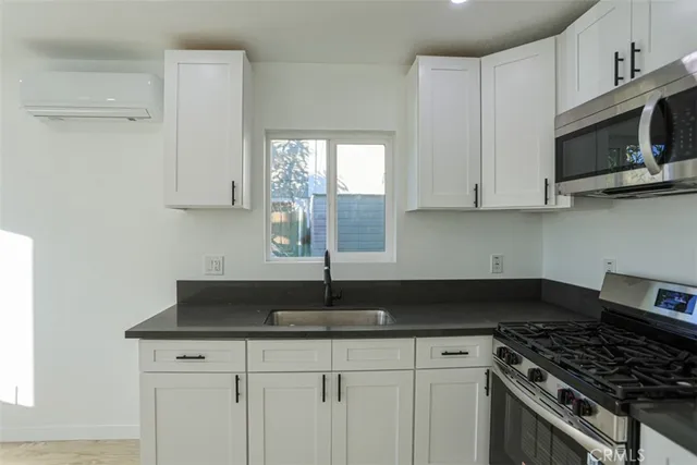 a kitchen with granite countertop white cabinets and stainless steel appliances