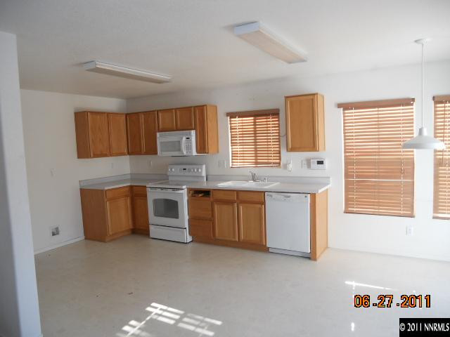 7732 Corso Street Reno, NV 89506 - Photo 6 of 13 a kitchen with a stove a sink and a microwave