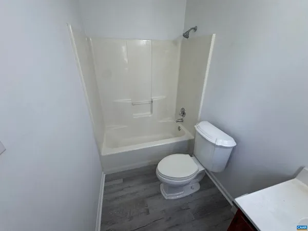 a white toilet sitting next to a bath tub