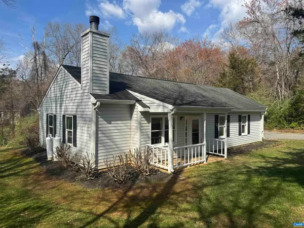a view of a house with a wooden deck and a yard