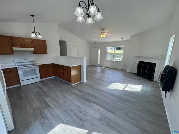 a view of a kitchen with cabinets wooden floor and window