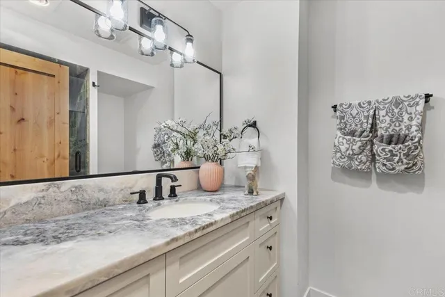 a bathroom with a granite countertop sink and a mirror