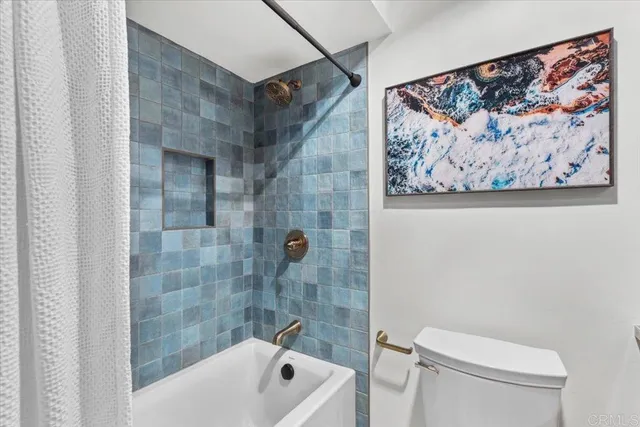 a bath room with a toilet and a shower curtain