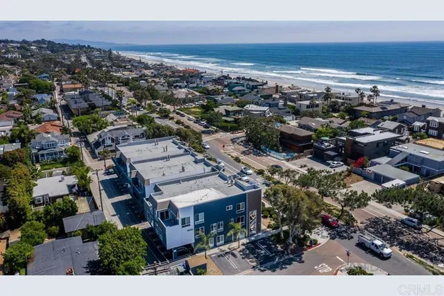 a view of brick house with large windows and plants