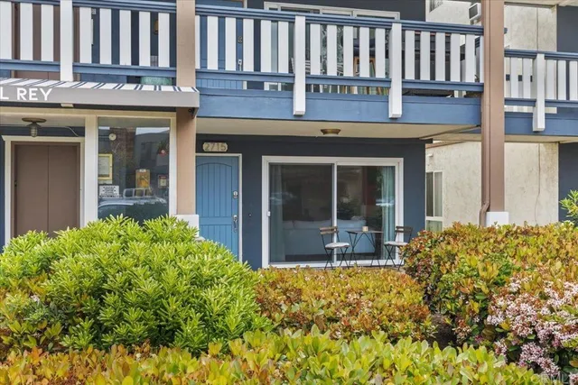 a view of brick house with large windows and plants