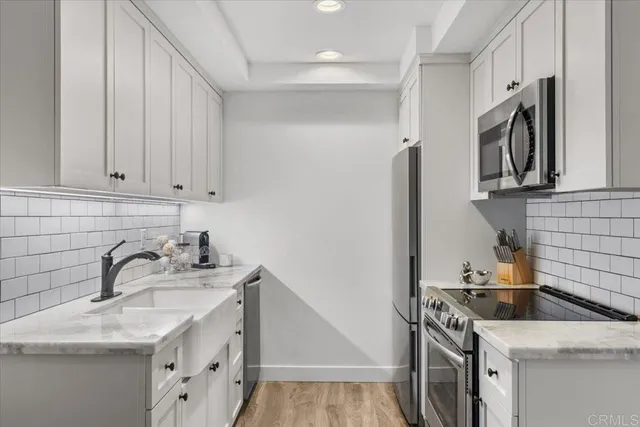 a kitchen with stainless steel appliances granite countertop a sink stove and refrigerator