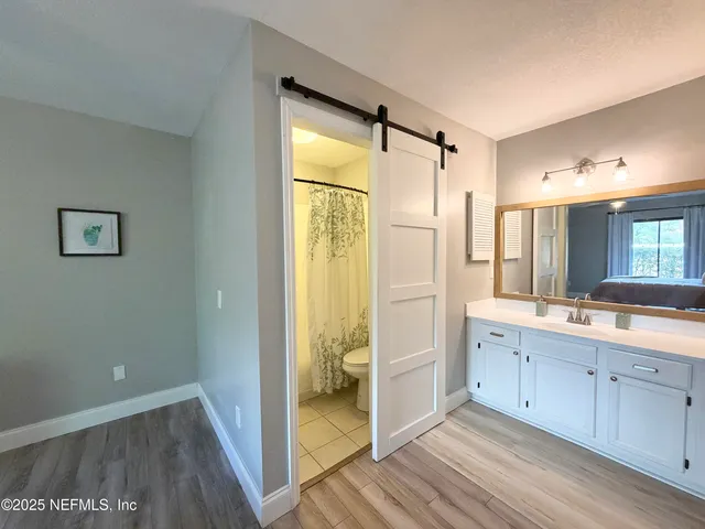 a bathroom with a glass shower door and a sink